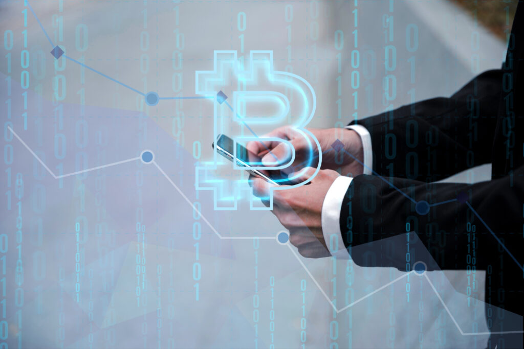 A person in a suit holding a smartphone, with a translucent Bitcoin symbol overlay and digital data in the background.