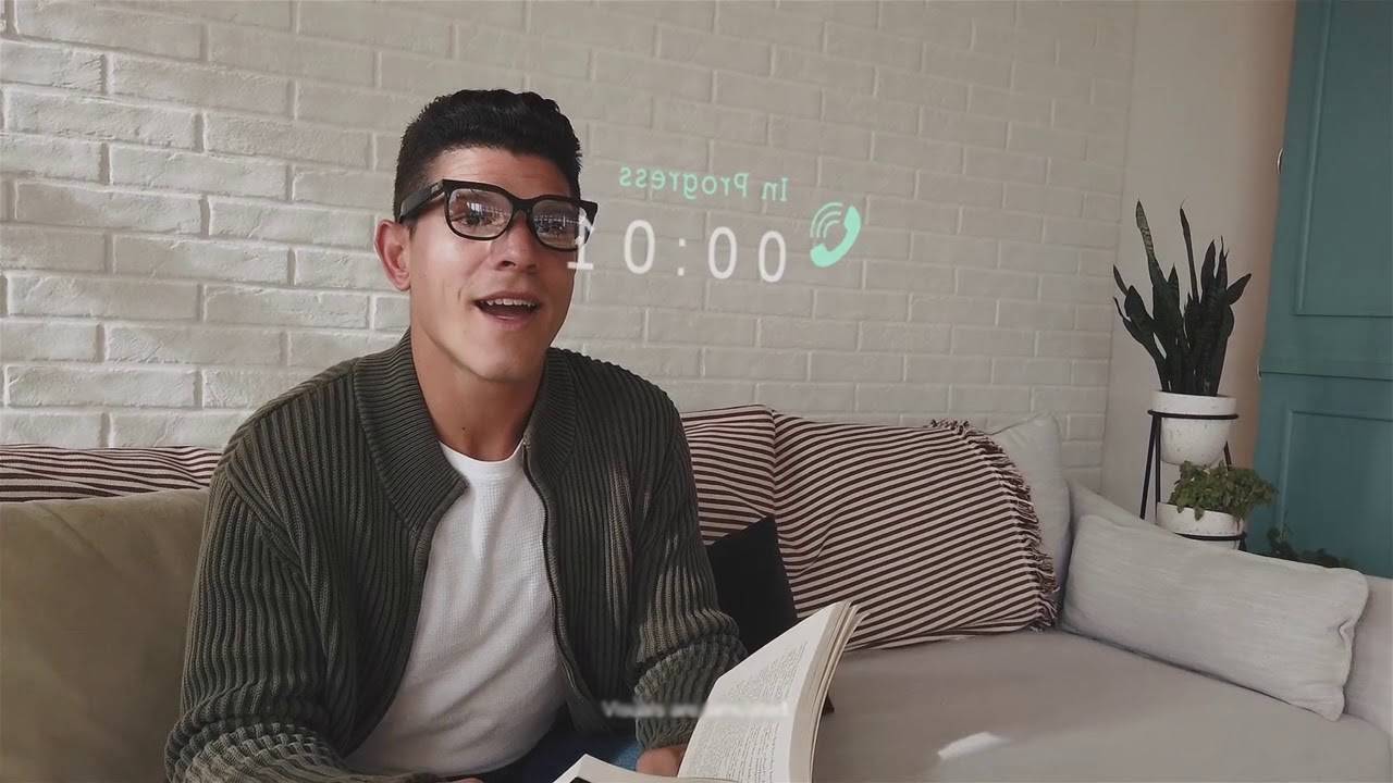  A person sitting on a couch with a book open, a timer projected on the wall, and indoor plants in a cozy room setting.