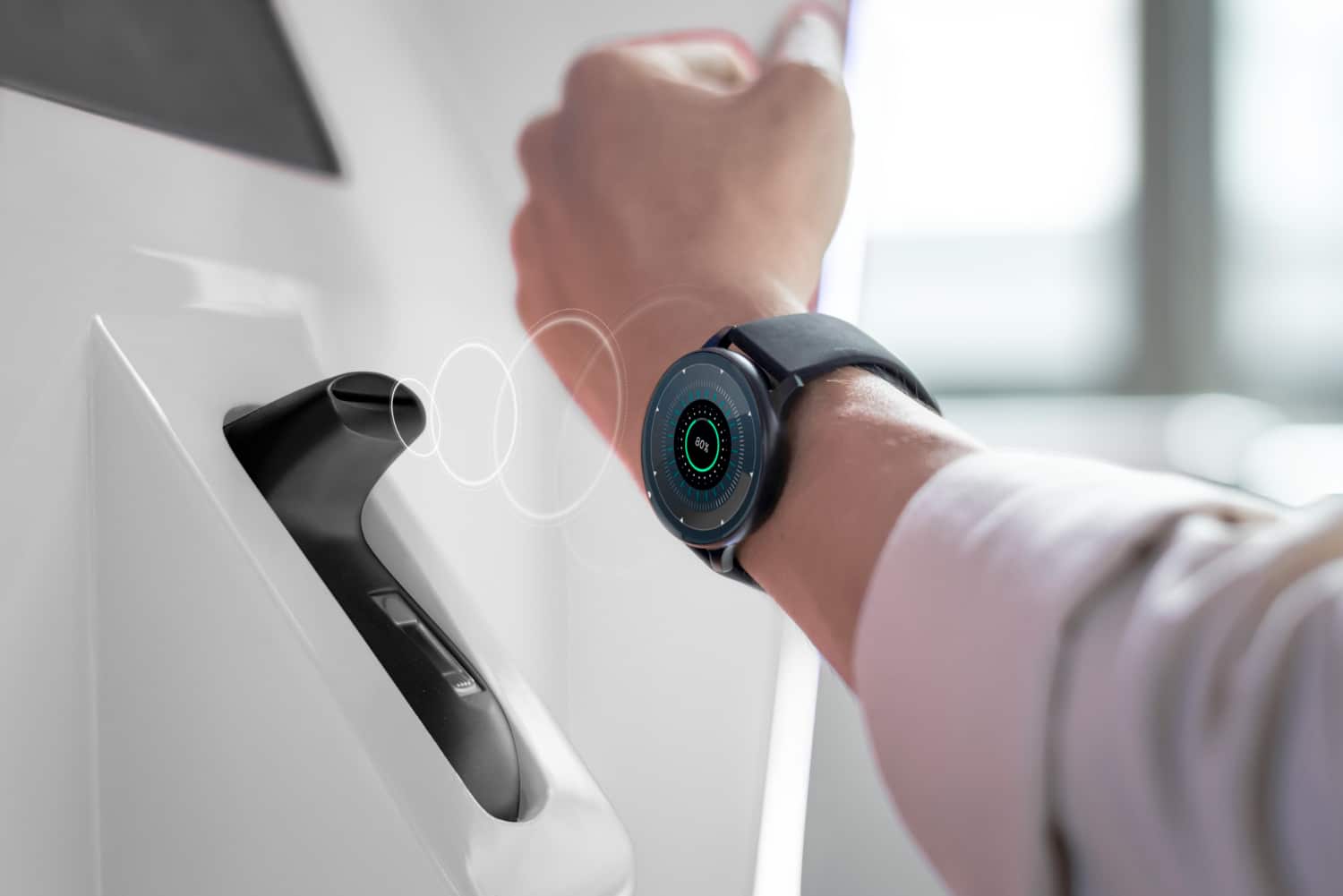 A person uses a smartwatch to pay at a contactless terminal, demonstrating modern payment technology in action.