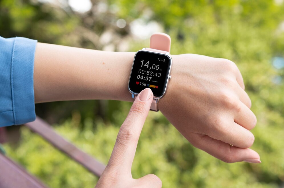 A close-up of a hand pointing at a smartwatch displaying workout stats: distance, time, heart rate, and pace, set against a green backdrop.