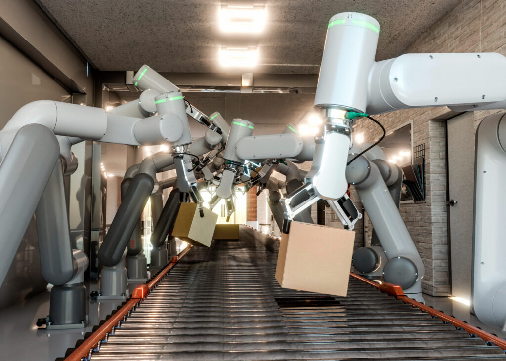 A series of robotic arms with green indicators are efficiently handling boxes on a conveyor belt in a modern industrial setting.