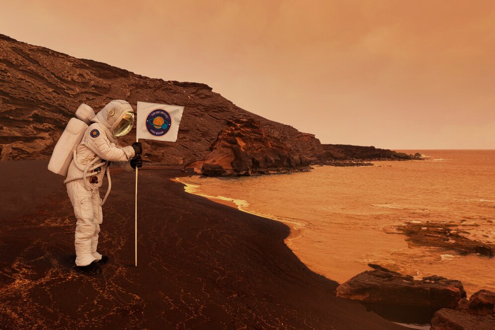 An astronaut stands on a rocky, alien shoreline, holding a flag amidst a hazy orange atmosphere and murky waters.