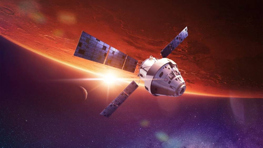 A spacecraft orbits Mars, illuminated by a distant star, with a moon visible, amidst a vibrant cosmic backdrop.