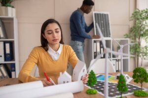 A woman and a man collaborate on a project at a desk in a modern office setting.